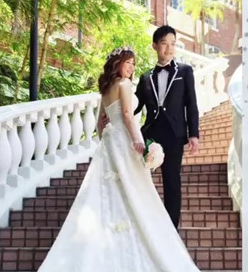 Bride and groom in wedding attire on outdoor garden stairs