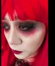 Dramatic character makeup with a red fringe and smoky eyes