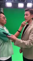 WaiTo applying makeup to a performer in front of a green screen